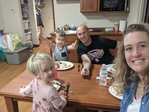 Happy family smiling and eating at the dinner table at the Akron House