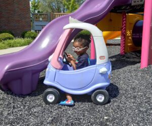 little boy in toy car on playground