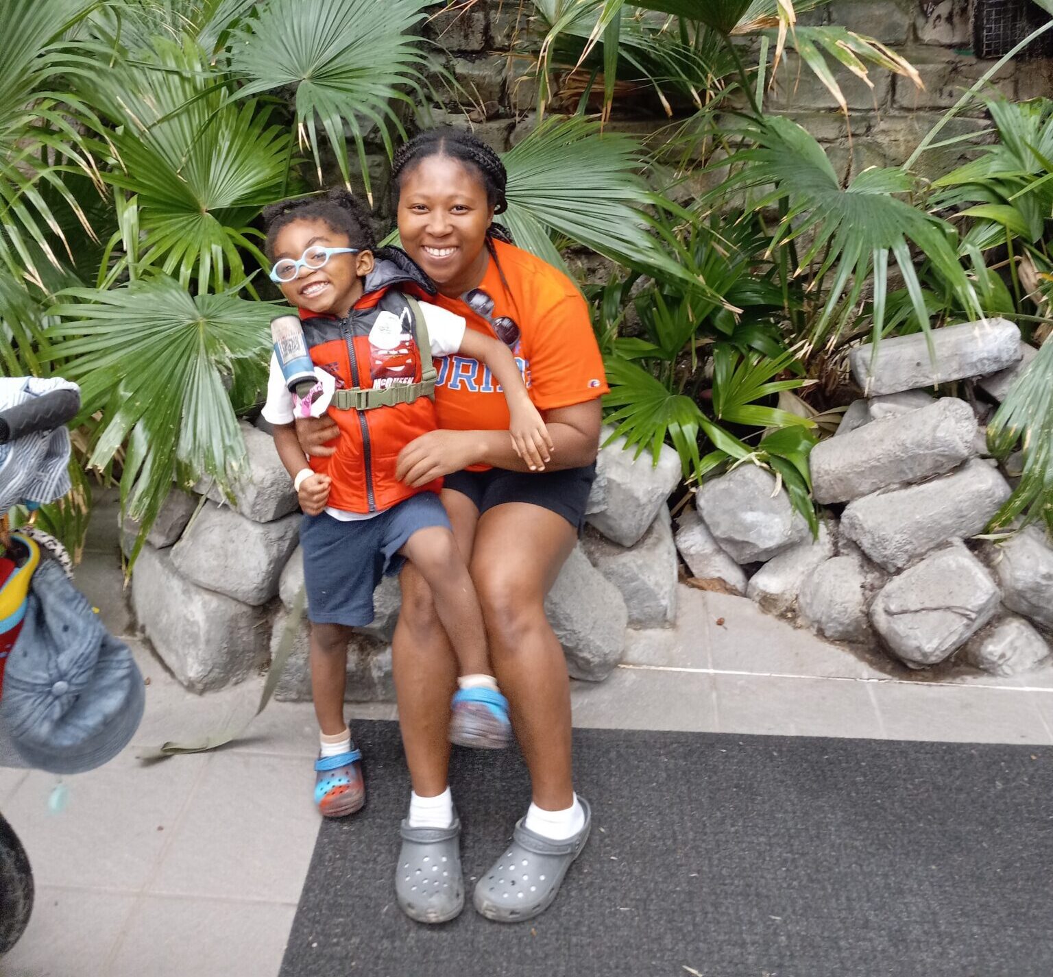 mom and son smiling for photo in rainforest at zoo exhibit