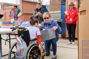 little girl in wheel chair getting a prize