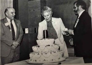 3 board members cutting cake