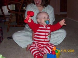 Carter Nedley smiling while playing with toys