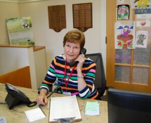 Barb Fisher on phone at volunteer desk