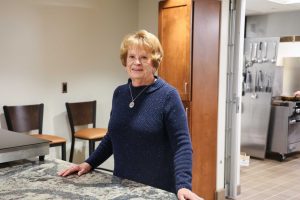 Volunteer Darlene Lewis stands at serving counter.