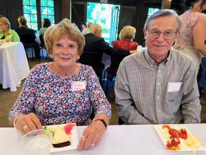 Two volunteers, man and woman, at table at an event.