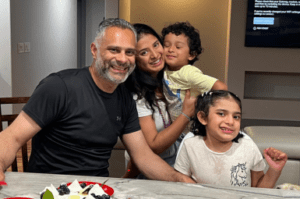 Giri Kotak family smiling in front of cake