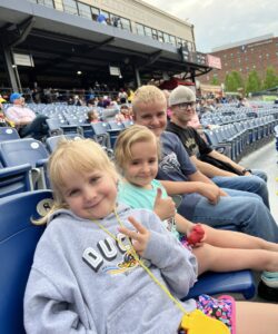 Four children in seats in baseball park