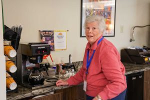 Volunteer Lois Reaven makes coffee 