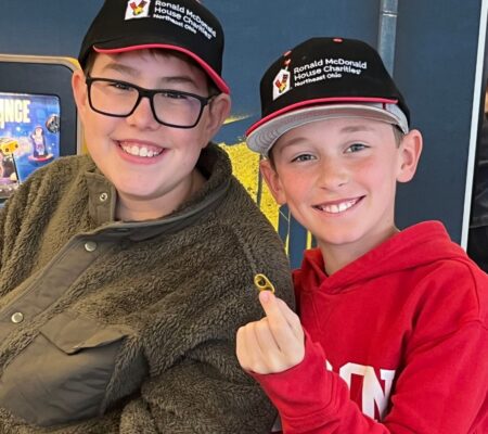 Two boys in RMHC NEO ball caps pose smiling, with a pull tab shown to start their collection.